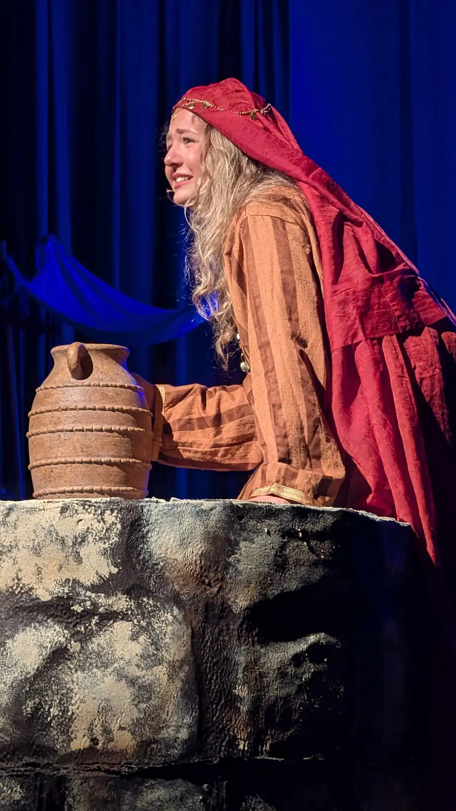 A woman at the well beside a clay vessel
